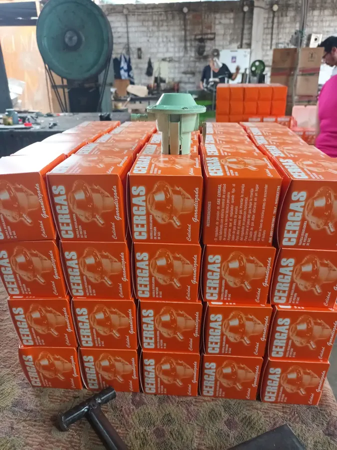 Cajas naranjas de válvulas reguladoras CERGAS apiladas en la fábrica